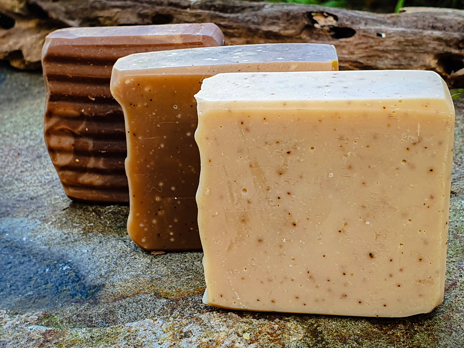 Three different shades of brown coffee scrub body bars handcrafted by Evee Ivy Oh artfully displayed (hopefully) on stone and wood. Our soups are eco friendly -Proudly 100% palm oil and plastic packaging free. 