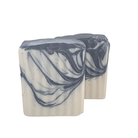 Image showing activated charcoal + eucalyptus body bar. This soap is white with a black activated charcoal swirl. Two bars in this image.